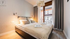 a bedroom with a large bed with a large window at Flatbook - City Center SPA Apartments Motlawa in Gdańsk