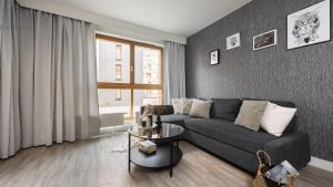 a living room with a couch and a table at Flatbook - City Center SPA Apartments Motlawa in Gdańsk