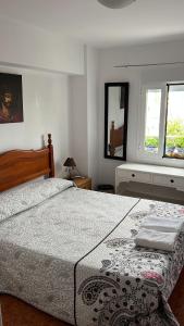 a bedroom with a large bed and two windows at Bonitas habitacións en piso compartido casa antonio in Seville