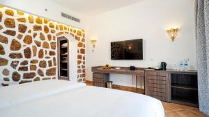马萨阿拉姆Pickalbatros Villaggio Aqua Park - Portofino Marsa Alam的酒店客房,设有石墙 更多37张照片