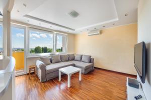 ein Wohnzimmer mit einem Sofa und einem TV in der Unterkunft Apartamenty Sun & Snow Gdynia Centrum in Gdynia
