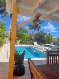 a patio with a table and a swimming pool at Tropical in Orient Bay French St Martin