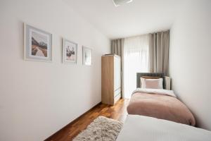 a bedroom with two beds and a window at Wola Sunset Apartment FREE Parking in Warsaw
