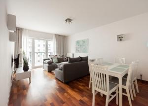 a living room with a couch and a table at Wola Sunset Apartment FREE Parking in Warsaw