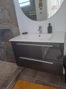 ein Bad mit einem Waschbecken und einem Spiegel in der Unterkunft Tropical in Orient Bay French St Martin