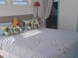 una camera con letto bianco e cuscini di Tropical a Orient Bay French St Martin