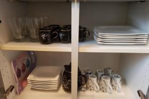 - un garde-manger avec des assiettes, des tasses et de la vaisselle dans l'établissement 2 Rooms Apartment in Triberg, à Triberg