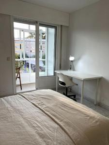 a bedroom with a bed and a desk and a window at El apartamento de Ordes in Órdenes