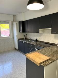 a kitchen with black cabinets and a counter top at El apartamento de Ordes in Órdenes +21 photos