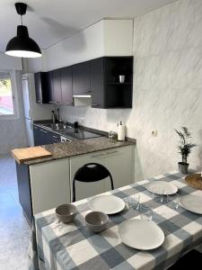 a kitchen with a table with plates and bowls on it at El apartamento de Ordes in Órdenes