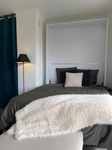 a bedroom with a bed with a white rug on it at Cozy studio on the beach in Antibes