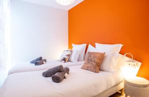 two beds in a room with orange walls at Annecy Lake Central in Annecy