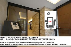 a sign on the door of a building with a cell phone at BRANCHERA NAHA AKEBONO PREMIST 1206 in Naha