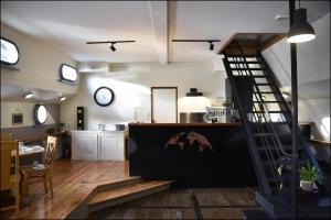 a living room with a staircase and a kitchen at Péniche Rayclau in Ronquières