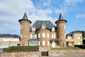 een groot bakstenen huis met drie torens bij Château de Chimay - Appt en front de mer in Barneville-Carteret