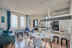 a kitchen and living room with a table and chairs at Château de Chimay - Appt en front de mer in Barneville-Carteret
