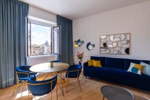 een woonkamer met een blauwe bank en een tafel en stoelen bij Navona 49 Luxury Suites&Apartment in Rome