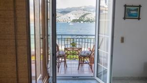 a room with a balcony with a view of the water at Marina Studios I in Argostoli