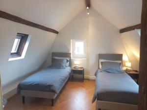 two beds in a attic room with two windows at COUL'Ô'BERGE in Coulanges-lès-Nevers