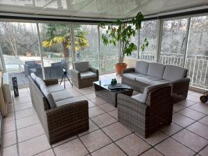 a screened in porch with couches and a table at COUL'Ô'BERGE in Coulanges-lès-Nevers