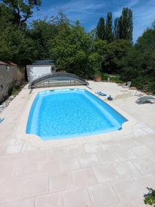 una piscina en un patio trasero con suelo de baldosa y una piscina en COUL'Ô'BERGE, en Coulanges-lès-Nevers