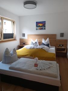una camera con due letti con lenzuola gialle e bianche di Alpenoase a Schwendau