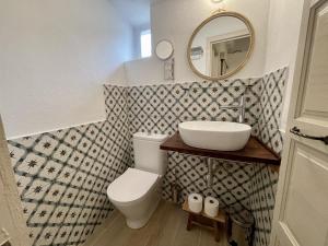 a bathroom with a sink and a toilet and a mirror at Casa en el Puerto de Denia in Denia +9 photos