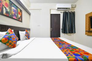 a bedroom with a bed with a colorful blanket on it at FabExpress Golden Villa in Indore