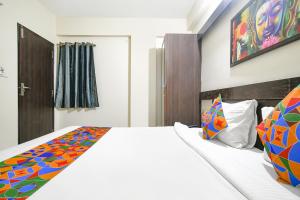 a bedroom with a bed with a colorful blanket on it at FabExpress Golden Villa in Indore