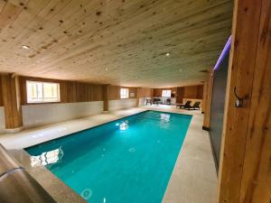 a swimming pool in a house with a wooden ceiling at Ash Cottage in Hope