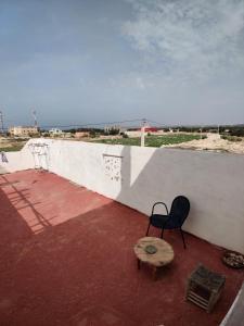 a black chair and a table on a roof at Hippie Chic House in Sidi Kaouki