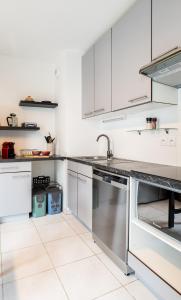 a kitchen with white cabinets and a sink at Annecy Lake Central in Annecy