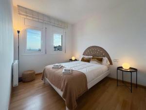 een slaapkamer met een groot bed en 2 ramen bij Hauzify I Apartament Can Reig in San Pol de Mar