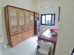 a kitchen with a wooden table and white chairs at Prime House Muntilan in Muntilan