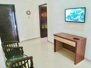 a room with a desk and a tv on a wall at Prime House Muntilan in Muntilan