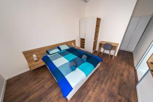Un dormitorio con una cama azul y blanca y una silla en Central Luxury 1 en Cluj-Napoca