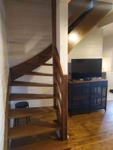 a wooden staircase with a television and a desk at Zbychowskie Zacisze in Zbychowo