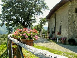 uma cerca com flores ao lado de um edifício em Country Farm em Vernio