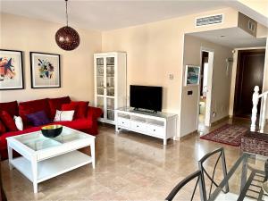 sala de estar con sofá rojo y TV en Casa Antonio, en Montejaque