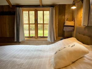 1 dormitorio con 1 cama blanca grande y ventana en The Walnut Wagon in the heart of Mells., en Frome