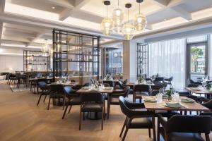 a restaurant with tables and chairs and windows at Tirana Marriott Hotel in Tirana
