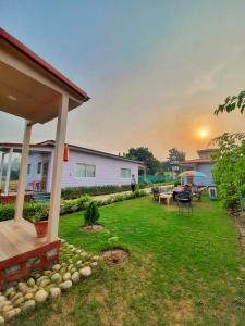 a backyard of a house with a table and chairs at Corbett VEDA INN in Rāmnagar