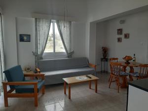 ein Wohnzimmer mit einem Sofa, Stühlen und einem Tisch in der Unterkunft Pangeras Apartments in Pissouri