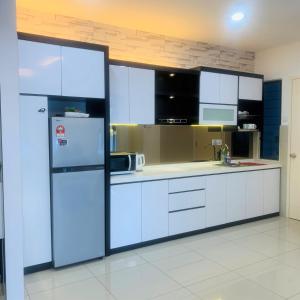  La cuisine est équipée de placards blancs et d'un réfrigérateur. dans l'établissement Atlantis Residence#3409#1Bedroom#2-4Pax#, à Malacca