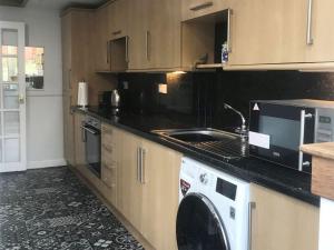 a kitchen with a washing machine and a sink at Victorias Haven in Kirkcaldy