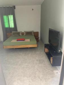a bedroom with a bed and a flat screen tv at Studio neuf independant dans villa in Ouoran