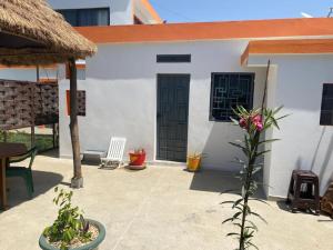 a white building with black doors and a patio at Studio neuf independant dans villa in Ouoran