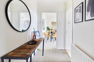 a hallway with a mirror and a table at The London Escape - Modish 1BDR Flat in London