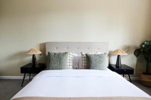 una camera da letto con un grande letto bianco con due lampade di The London Escape - Modish 1BDR Flat a Londra