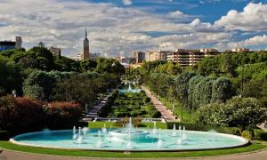 una fontana in un parco con una città sullo sfondo di Pensión Corona a Saragozza